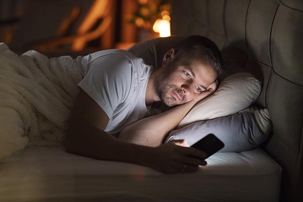 man in bed with phone