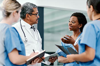 A doctor speaking with several nurses