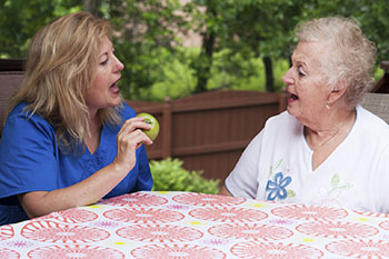A middle-aged woman speaking with an older-aged woman